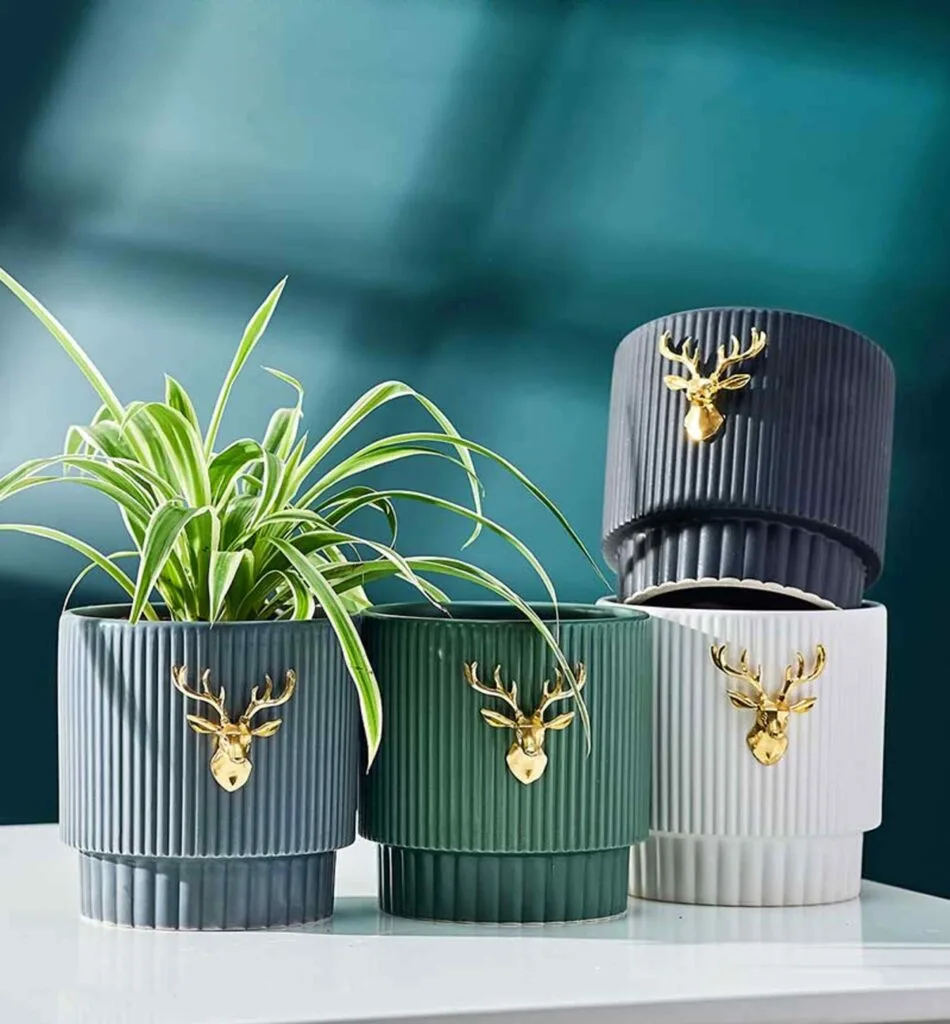Elegant ribbed ceramic planters with gold deer emblem, perfect for indoor plant décor.