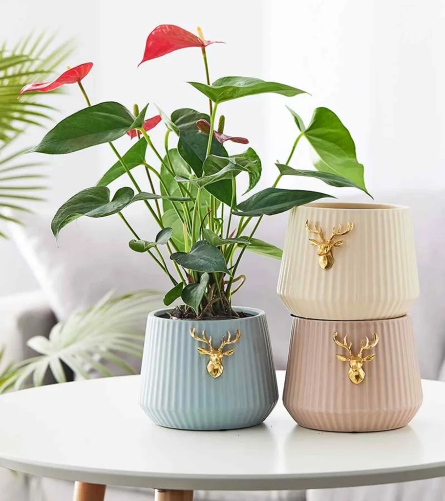 Elegant ribbed ceramic planters with gold deer accents, perfect for indoor plants and modern home decor.